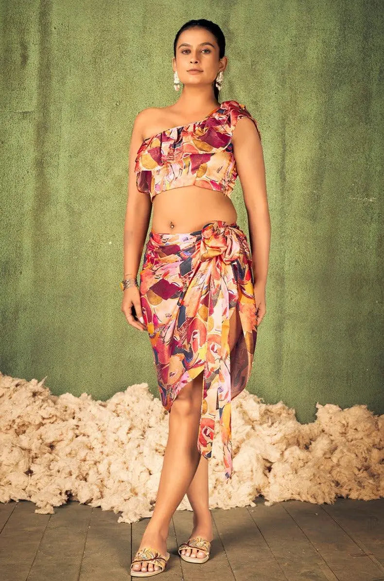 Woman wearing a colorful floral outfit against a green textured wall. [Abstract Print Beach Wear - Plus Size - Women]