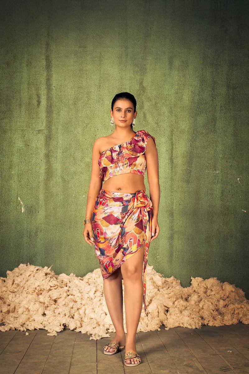 Woman in a floral dress standing against a green wall with white textured baseboard. [Abstract Print Beach Wear - Plus Size - Women]