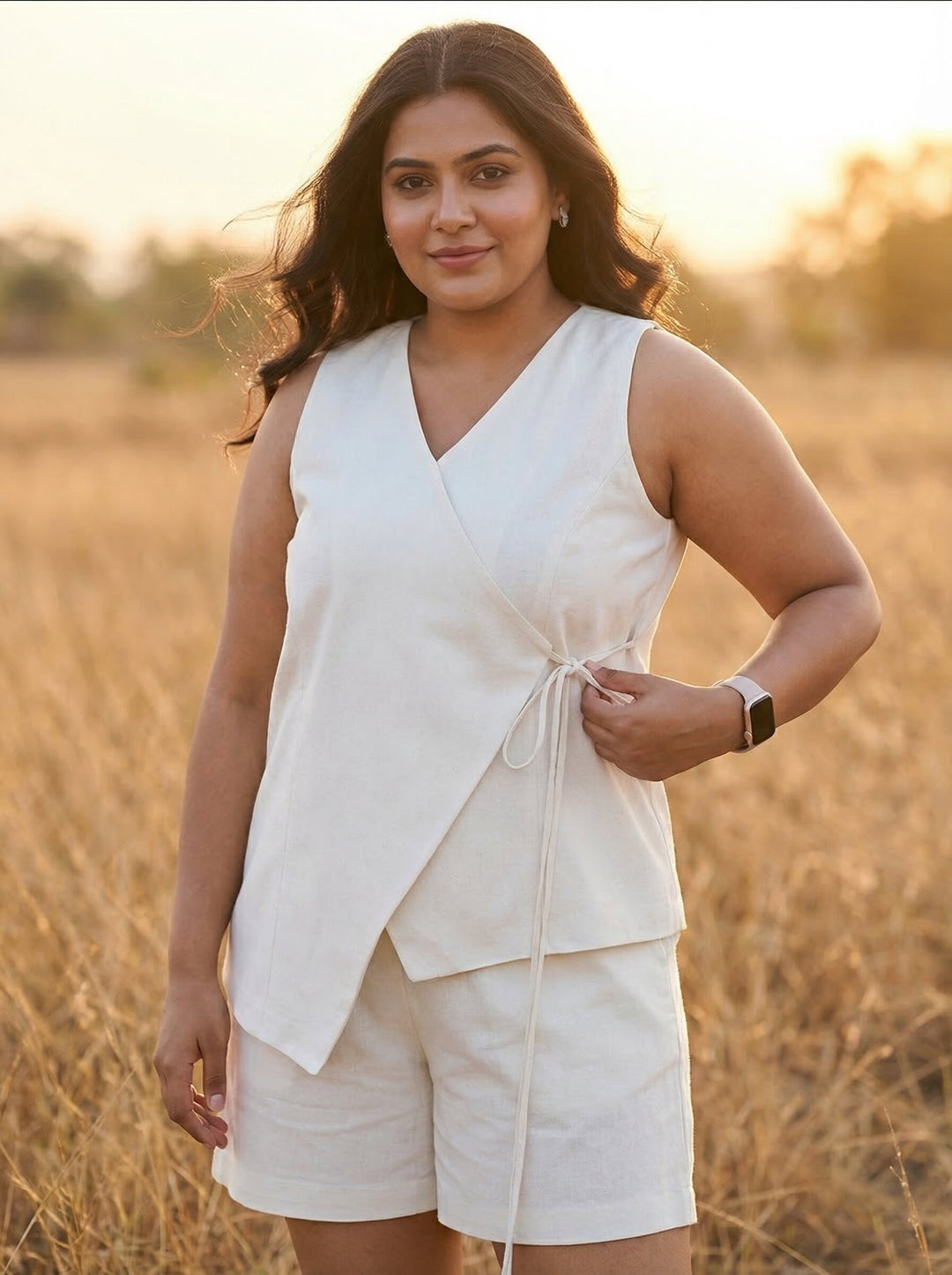 Woman in a white sleeveless top and shorts standing in a field with a warm glow [Buy Summer Co Ord Set for Women Online]