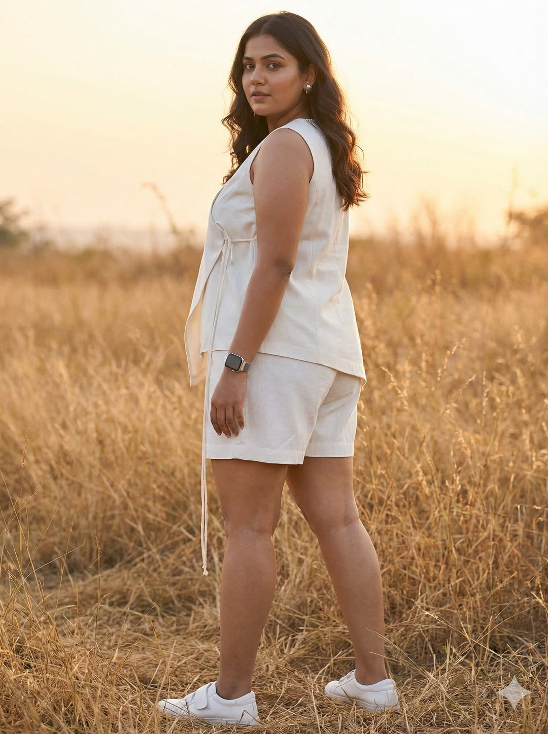 Woman in a white outfit standing in a field with a sunset background [Buy Summer Co Ord Set for Women Online]