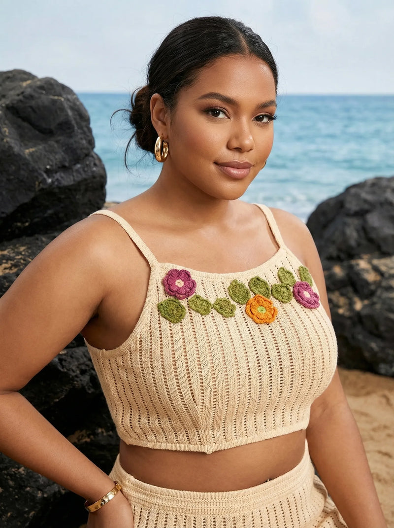 Woman wearing a beige crochet top with floral patterns against a beach background